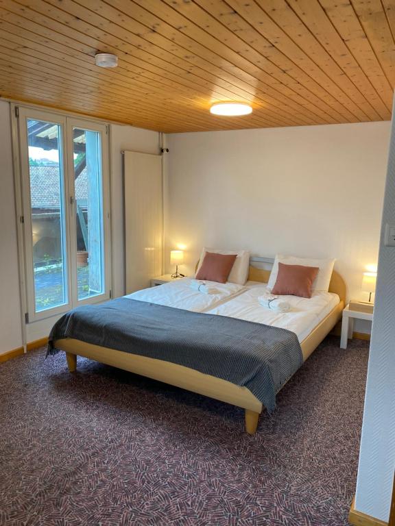a bedroom with a large bed with a wooden ceiling at Simple Room 1 in Oberbüren