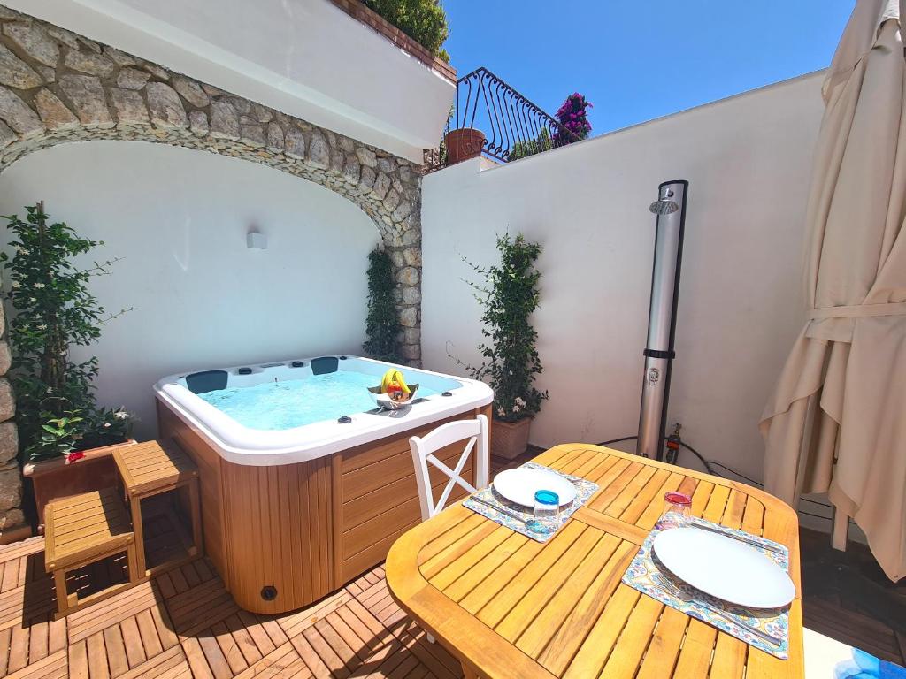 bañera de hidromasaje en una terraza con mesa en Tiberio House & Spa, en Capri