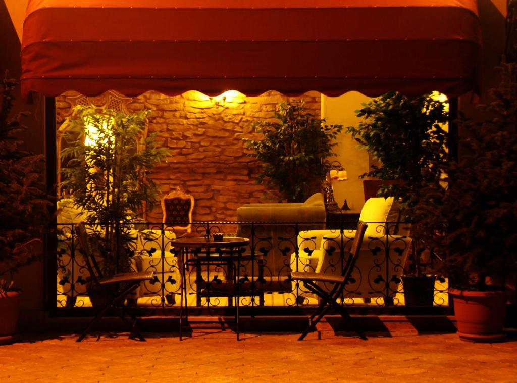 a patio at night with chairs and a stone wall at Edahan Hotel in Biga