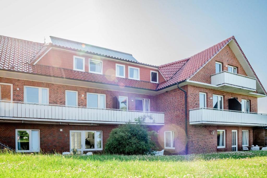 a red brick building with two balconies on it at Strandperle Appartements in Hasselberg