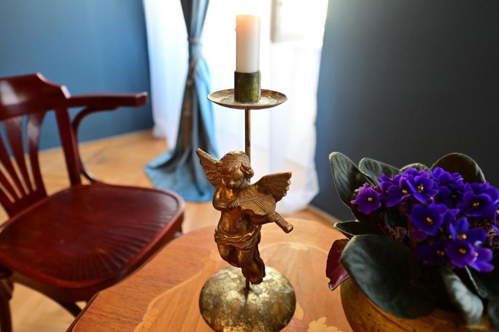 una estatua de un ángel sentado en una mesa con flores en Lovely 2 bedroom apartment in historic city center, en Sibiu