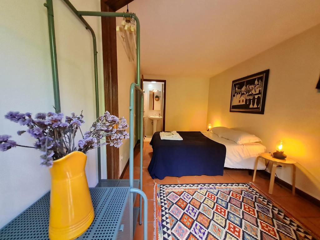 a small bedroom with a bed and a vase of flowers at Out of Town in Castelo de Paiva