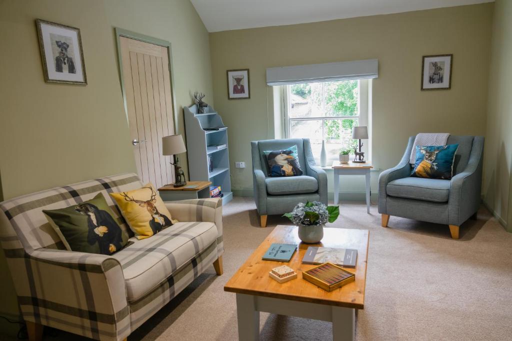 a living room with a couch and two chairs and a table at Acorn Apartment in York