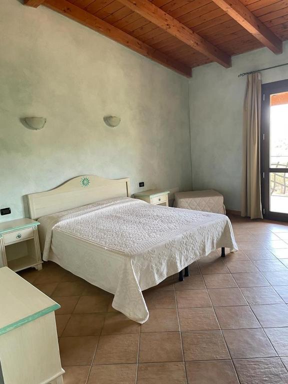 a bedroom with a white bed and a window at Agriturismo San Giovanni in Olbia