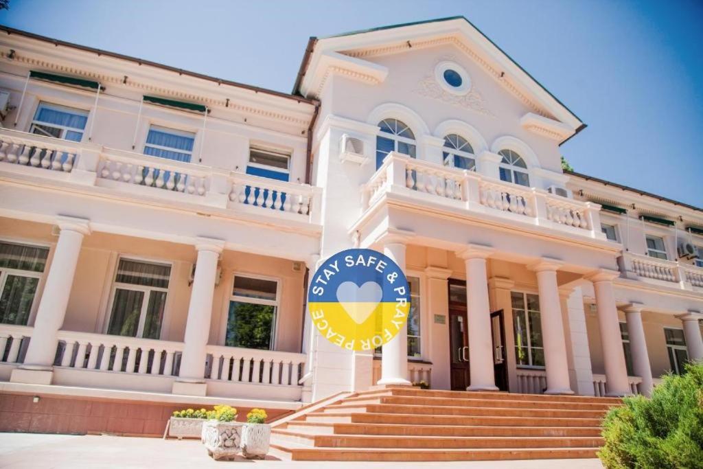 a large white building with a sign in front of it at Arcadia Plaza Hotel in Odesa