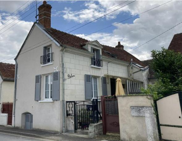 una casa blanca con una puerta delante de ella en Le Relax, en Saint-Aignan
