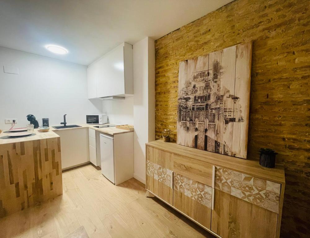 una cocina con una pared de madera con una pintura. en Casa del palmar suite en Valencia