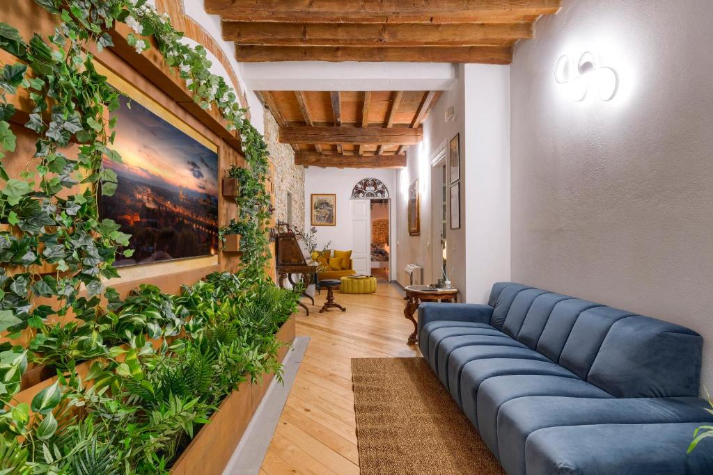 a living room with a blue couch and plants on the wall at Il Giardino Fiorentino - Luxury Apartment & Spa in Florence