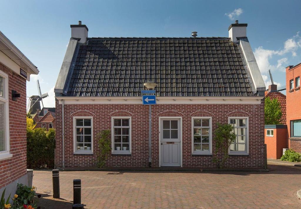 a red brick building with a black roof at Karakteristiek huis in centrum Winsum met nieuwe badkamer in Winsum