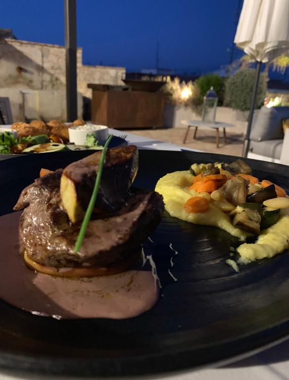 a plate of food with meat and vegetables on a table at La Serena Boutique Hotel & Wellness - Altea in Altea