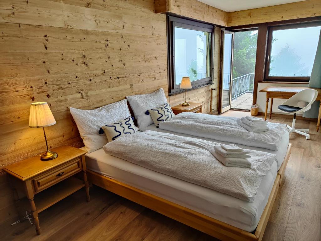a bedroom with a bed and a wooden wall at Hotel Bergsonne Rigi in Rigi Kaltbad