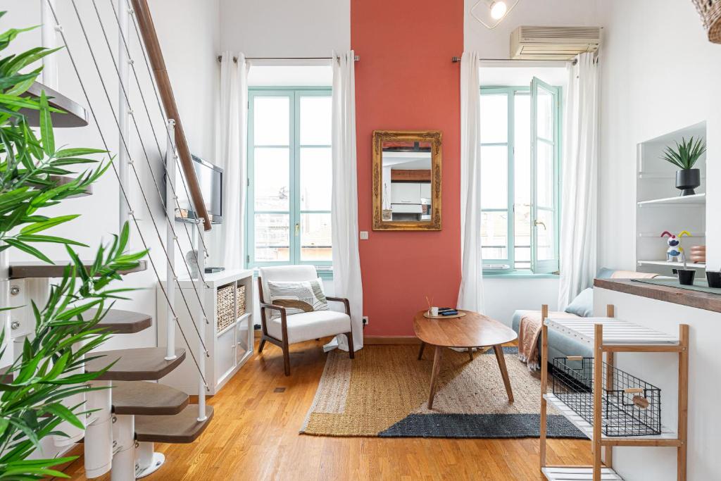un salon avec un mur d'accent orange dans l'établissement Plage et Shopping ! Appartement au cœur de Nice !, à Nice