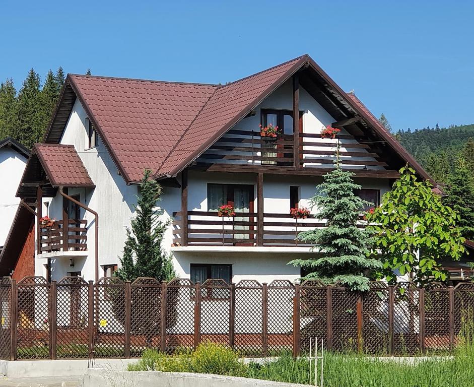 a house with a fence in front of it at Vila Flora în Gura Humorului in Gura Humorului