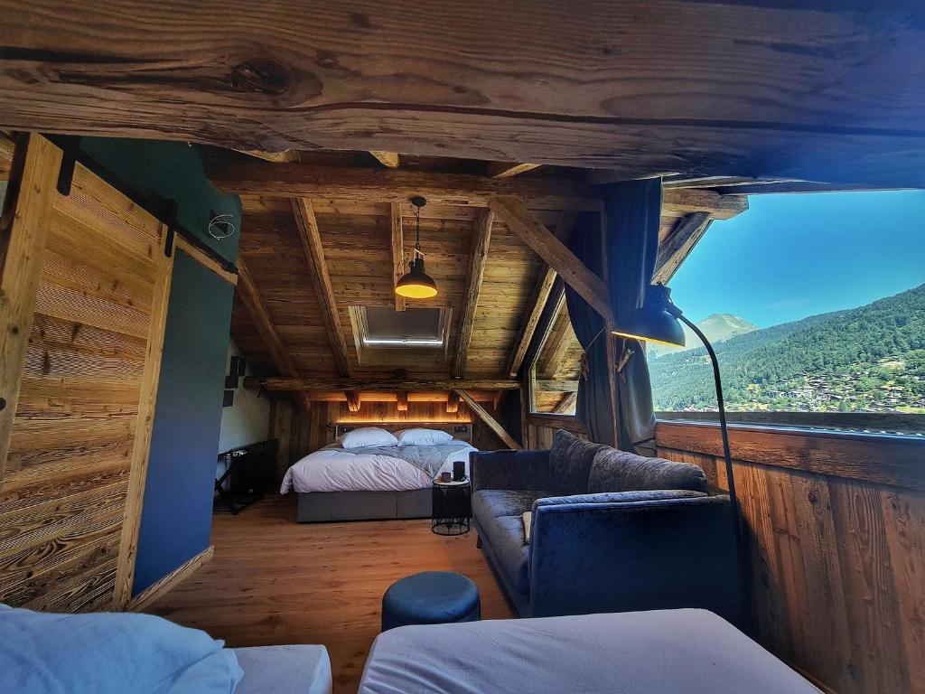 ein Zimmer mit einem Schlafzimmer und einem Bett in einem Haus in der Unterkunft Le PasSionNant in Morzine