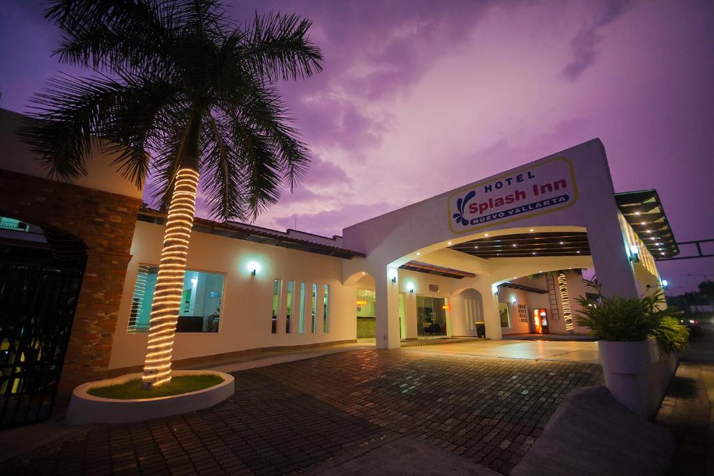 una palmera frente a un edificio por la noche en Splash Inn Nuevo Vallarta & Parque Acuatico en Nuevo Vallarta 