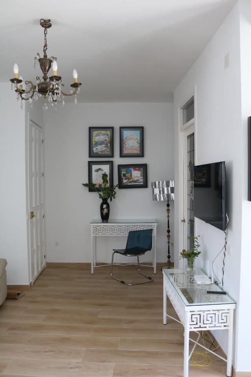 a living room with white walls and a table and a chair at casa dellamore in Cártama
