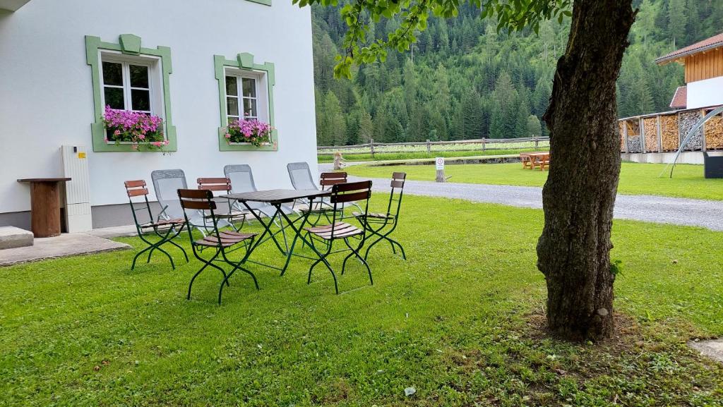 a table and chairs in a yard next to a tree at De Nussi's Chalet 4 in Bach