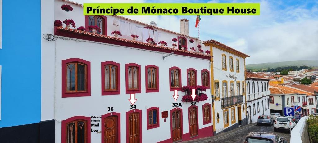 un edificio blanco con puertas y ventanas rojas en Príncipe de Mónaco Boutique House en Angra do Heroísmo