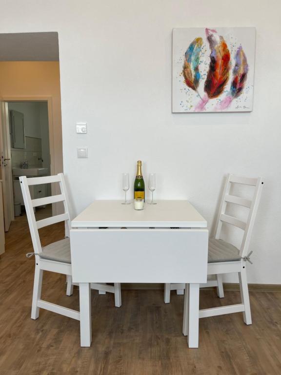 una mesa blanca con 2 sillas y una botella de vino en Apartment in Mayen Zentrum nur 100 Meter, en Mayen