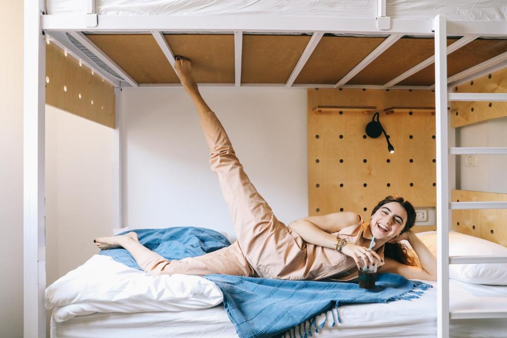 a woman laying on a bed in a bunk bed at Gia Dormitory in Tel Aviv