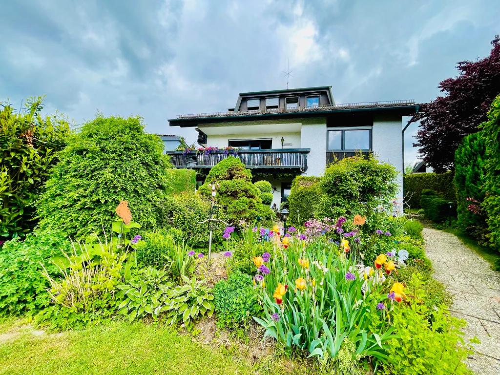 a house with a garden with flowers in front of it at Ferienwohnung Boller I für 2 Personen in Marktredwitz