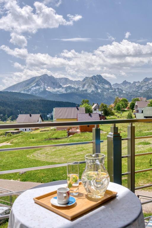 扎布利亚克Peak of Durmitor Panorama的一张桌子,上面有玻璃瓶和两杯玻璃杯