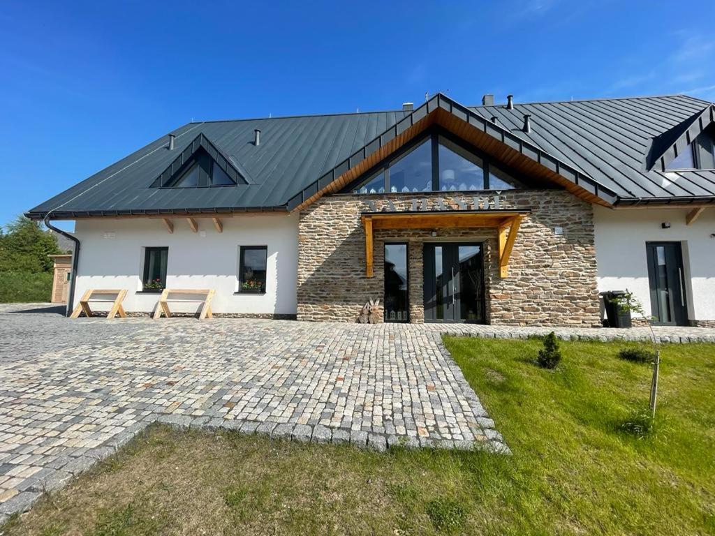 a stone house with a black roof at Apartmány Na handě in Boží Dar