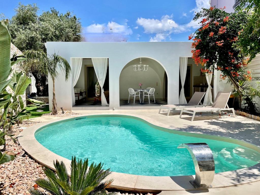 una piscina nel cortile di una casa di Byblos Aria-The Sea Side Luxury Villa a Skala Sotiros