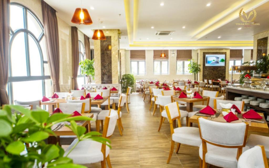 a restaurant with tables and chairs with red napkins at Putin Hotel Nha Trang in Nha Trang