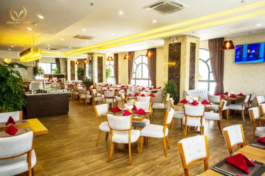 a restaurant with white chairs and tables and red napkins at Putin Hotel Nha Trang in Nha Trang