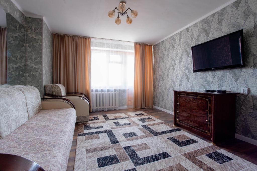 a bedroom with a bed and a tv and a fireplace at 2-х комнатная квартира в центре по ул. Козыбаева д.107 in Kostanay