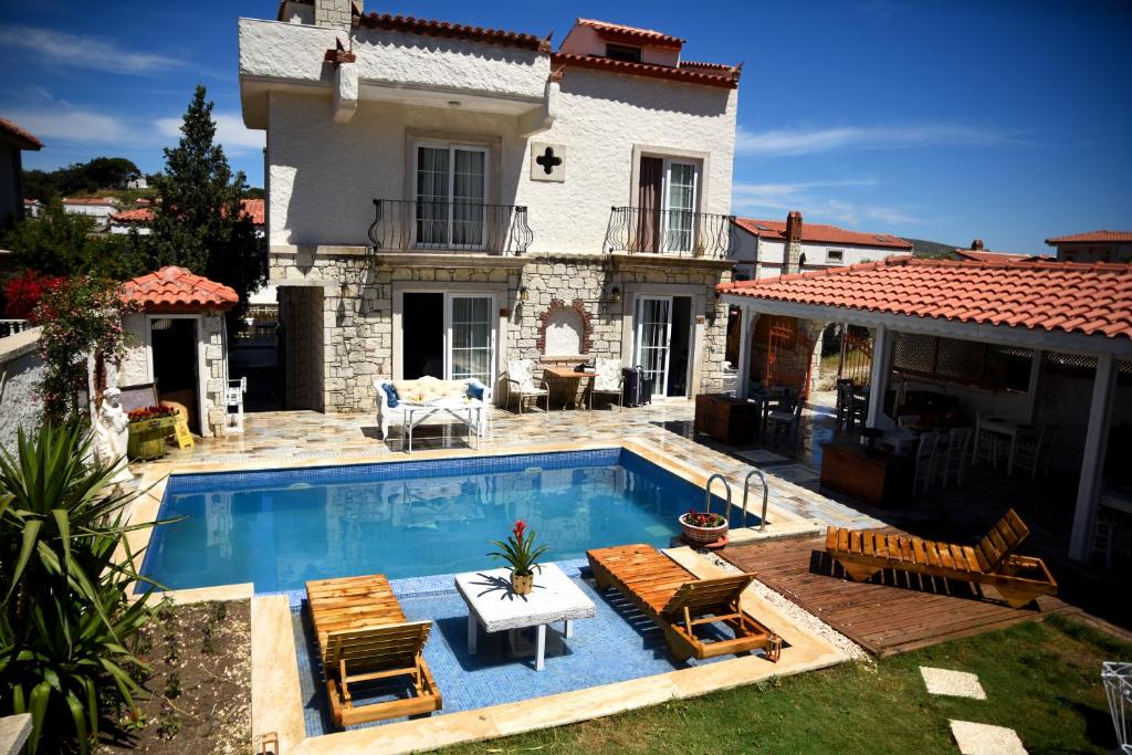 a house with a swimming pool in front of a house at Naz Konak Alaçatı in Alacati