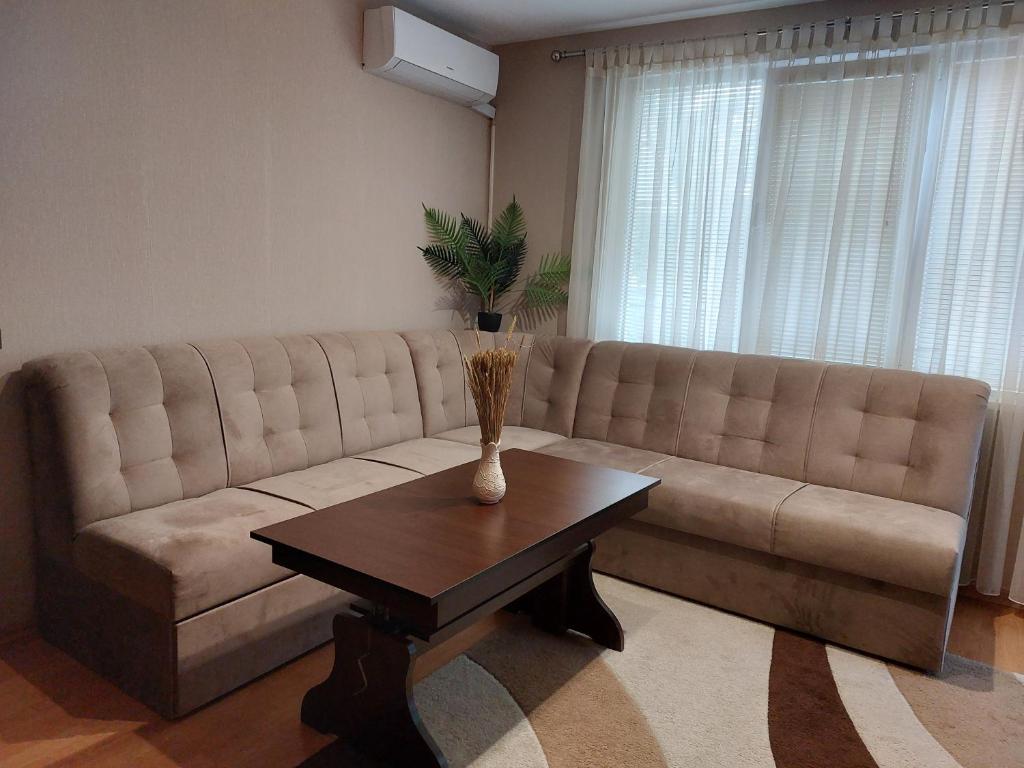 ein Wohnzimmer mit einem Sofa und einem Couchtisch in der Unterkunft апартамент за гости Георгиеви in Weliko Tarnowo