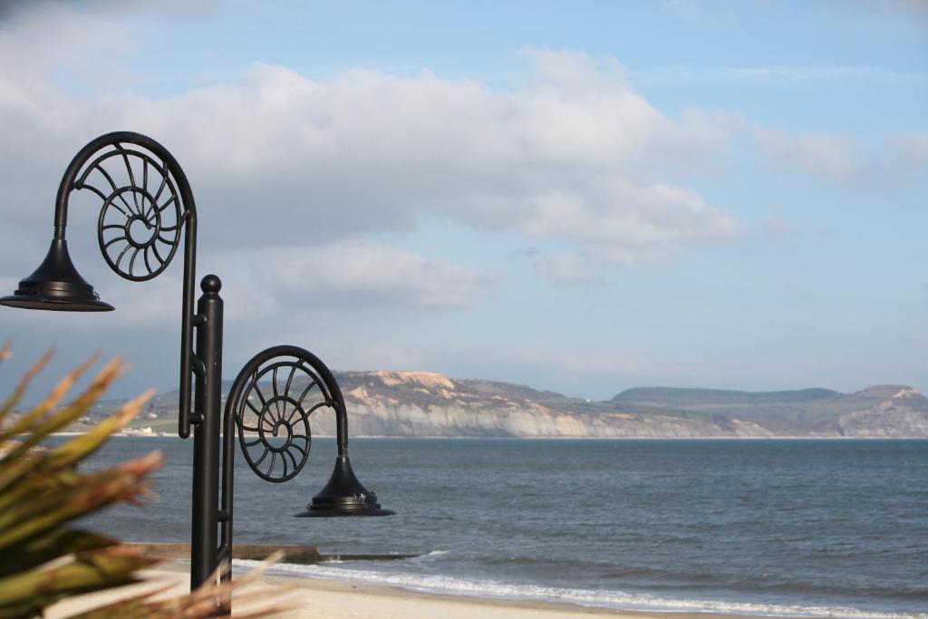 a couple of lights on a beach with the ocean at Fernhill Hotel in Lyme Regis
