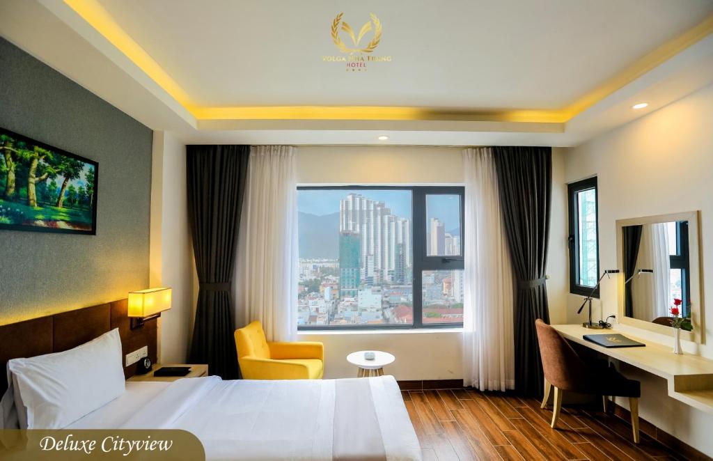 a hotel room with a bed and a desk and a window at Putin Hotel Nha Trang in Nha Trang