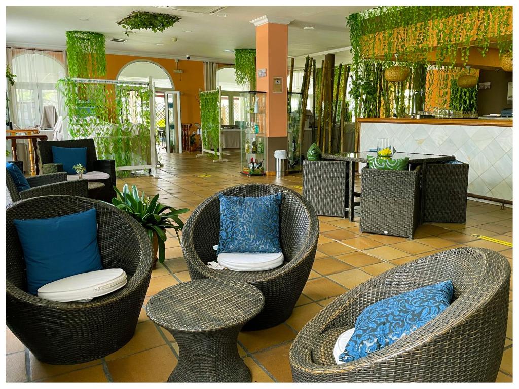 a lobby with three chairs with blue pillows at Hotel Albaida Nature in Mazagón