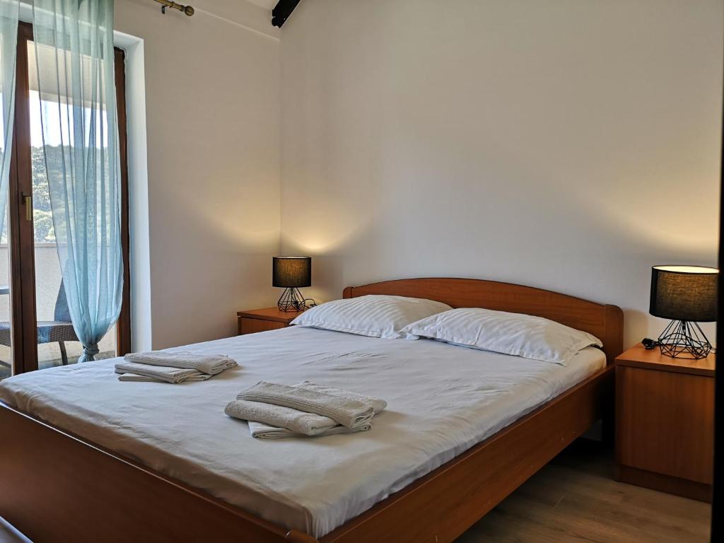 a bedroom with a bed with two towels on it at Guest House Pikala in Goveđari