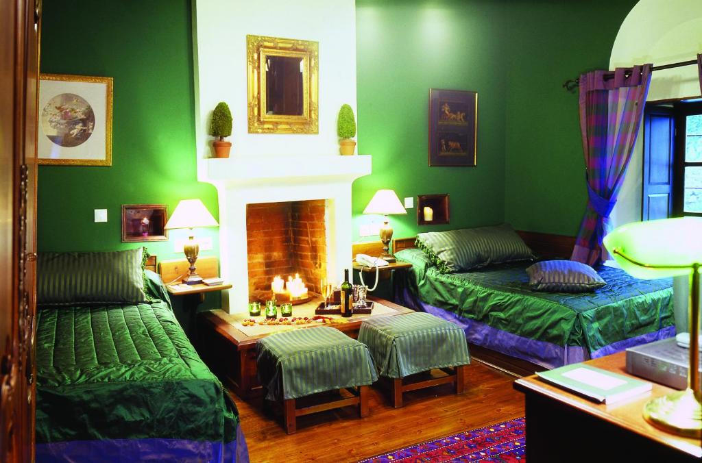 a green living room with two beds and a fireplace at Santikos Mansion in Vizitsa