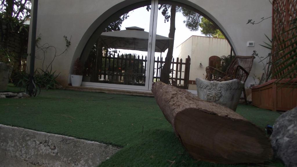 einen Hinterhof mit einem Torbogen mit einem Zaun und einem Garten in der Unterkunft Villa Genna in San Vito lo Capo