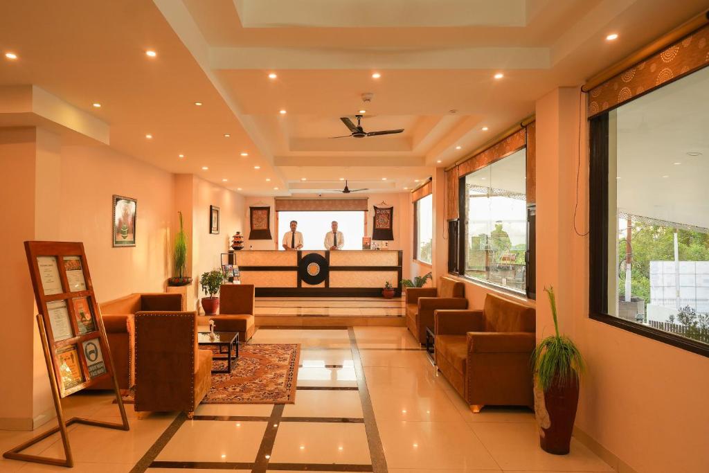 a lobby with chairs and a stage in the background at Hotel 360 by D'Polo Dharamshala in Dharmsala