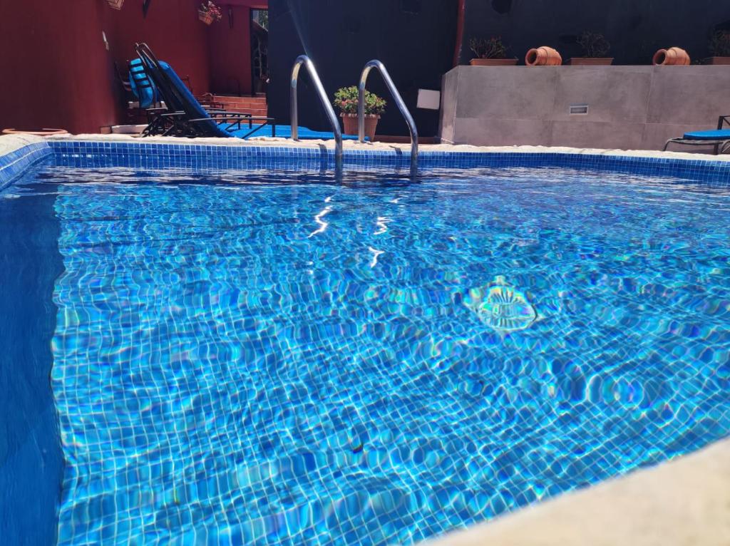 una gran piscina azul con agua azul en Casa La Gollada, en Cazadores