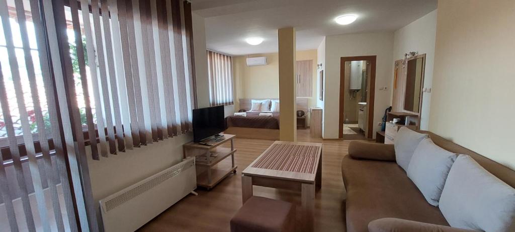een woonkamer met een bank en een tv bij Studio Paradise in Veliko Tŭrnovo