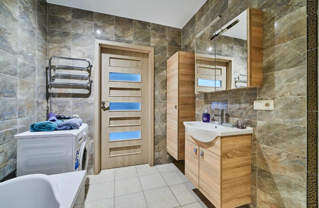 La salle de bains est pourvue d'un lavabo, de toilettes et d'un miroir. dans l'établissement Ozo Apartments, à Vilnius