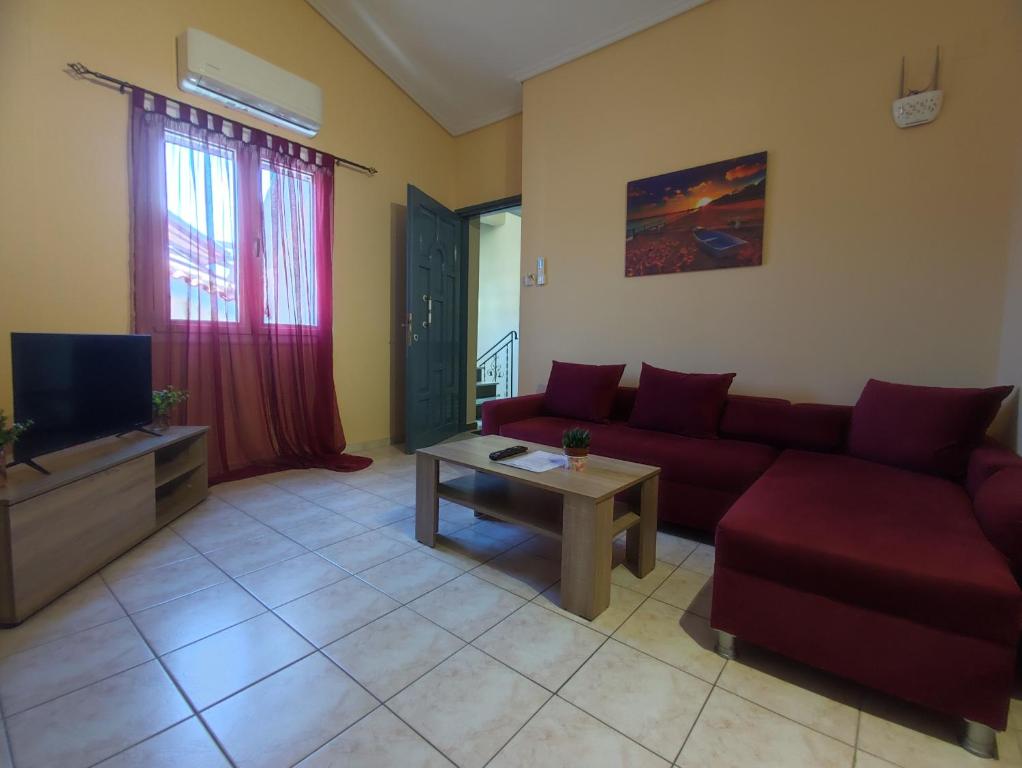 Una sala de estar con un sofá rojo y un televisor. en John's Apartment 4 in Argostoli, en Argostoli
