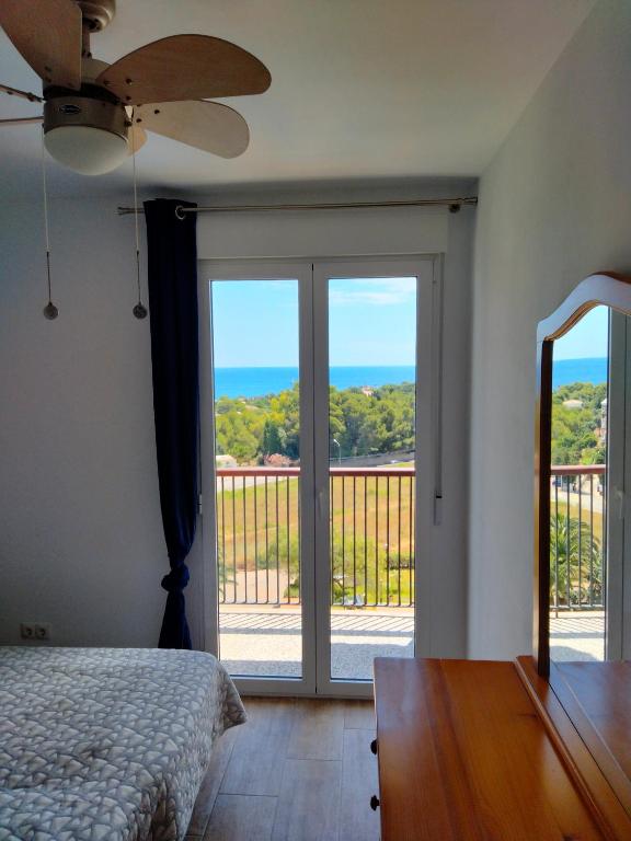a bedroom with a sliding glass door with a view of the ocean at Apartments Las Vinas in Denia