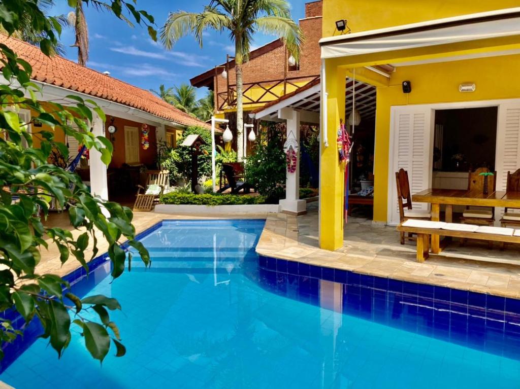 a swimming pool in front of a house at MOA Pousada in Guarujá