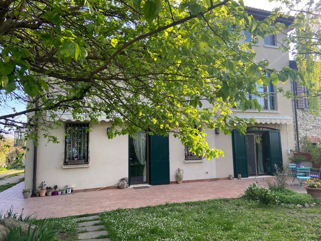 a white house with a green door and a yard at Monte Maino Bed & Breakfast in Desenzano del Garda