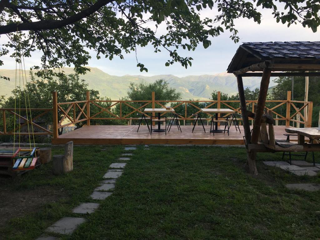 a patio with picnic tables and a view of mountains at Berkri Gastro Yard & Guest House in Yenokavan