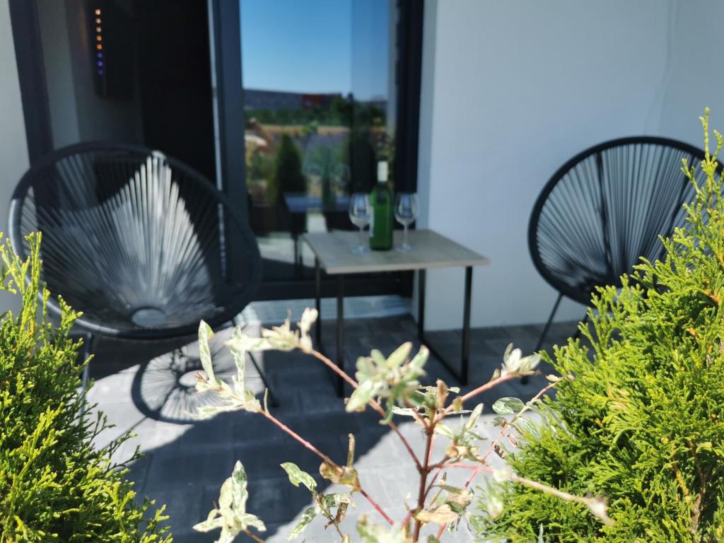 - deux chaises noires et une table sur la terrasse dans l'établissement Apartmani KA Sveti Martin, à Sveti Martin na Muri