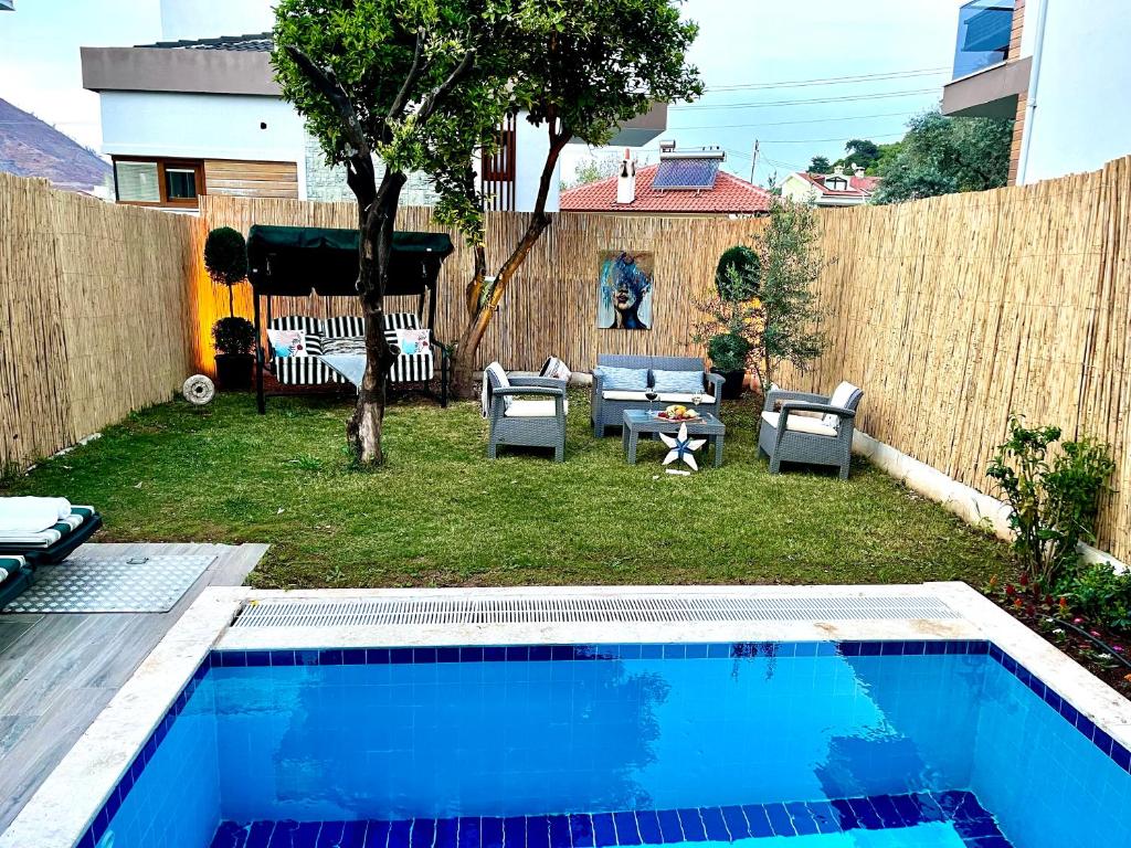 a backyard with a swimming pool and a fence at Seaview Grand - VILLA SUNRISE in Marmaris